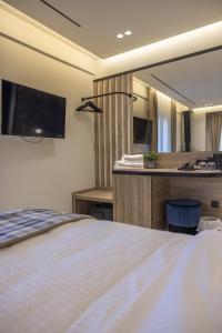 a bedroom with a bed and a large mirror at Polyzos Luxury Suites Meteora #6 - Adults Friendly in Kalabaka