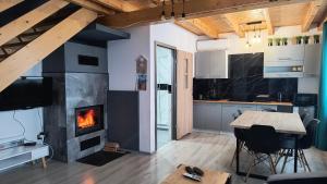 a kitchen with a fireplace and a table and chairs at Domki Mała Tresna in Bierna