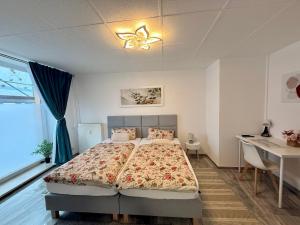 a bedroom with a bed and a desk and a window at Apartmenthaus Döbeln Zentrum 01 in Döbeln