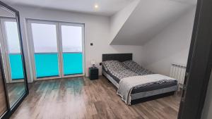 a bedroom with a bed and two large windows at Domki Mała Tresna in Bierna