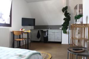 a bedroom with a kitchen with a table and chairs at L Atelier du Centre in Vendôme