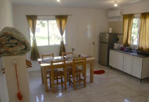 a kitchen with a table and chairs and a kitchen with a refrigerator at Lo de Ine in La Cumbre