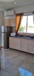 a kitchen with a stainless steel refrigerator and a window at Lo de Ine in La Cumbre +20 photos