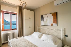 a bedroom with a white bed and a window at Villa Panoramica in Perledo