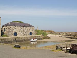 a boat in a body of water next to a building at Ivy Cottage in Mountblairy