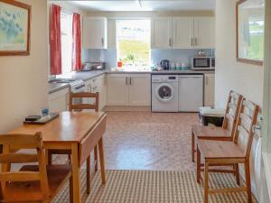 a kitchen with a table and chairs and a dining room at Ivy Cottage in Mountblairy