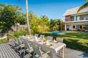 a white table and chairs on a deck next to a house at Ruby in Post of Flacq
