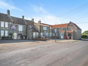an empty street in front of an old brick building at Black Bull Cottage in Ugthorpe