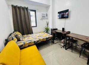a living room with a yellow couch and a table at Tower1 Smdc green2 Dasmarinas in Dasmariñas