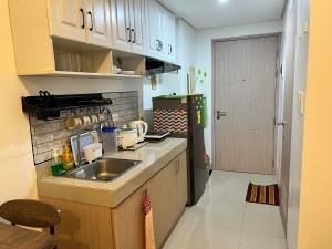 a small kitchen with a sink and a refrigerator at Tower1 Smdc green2 Dasmarinas in Dasmariñas