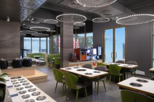 un ristorante con tavoli, sedie e finestre di HUAZHU LUYI Service Apartment 华住庐艺 a Riyad