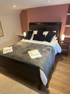 a bedroom with a large bed with two towels on it at The Hayloft in Oaksey +12 photos