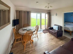 a living room with a table and chairs and a couch at No 1 Hickling Chalet - Uk51726 in Scratby