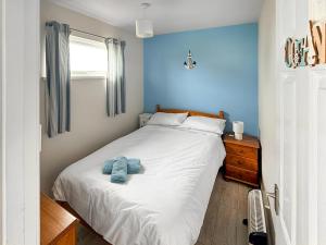 a bedroom with a bed with two towels on it at No 1 Hickling Chalet - Uk51726 in Scratby +2 photos