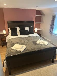 a bedroom with a large bed with two towels on it at The Hayloft in Oaksey