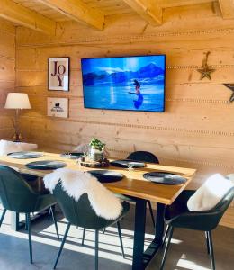 a dining room with a table and a tv on the wall at Ovis Homes I Gorąca balia - Widok na góry - 8 osób - Komfortowy domek in Zawoja