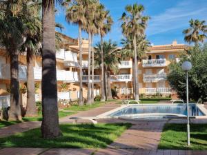 a resort with a swimming pool and palm trees at Appartement Stella vue mer in Piles
