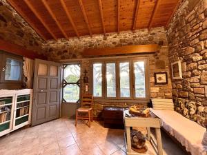 a room with a stone wall and a door and a table at Agroktima Konstantinos & Eleni in Platy