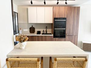 a kitchen with a table with two chairs at Le petit Berriat - Grenoble centre in Grenoble
