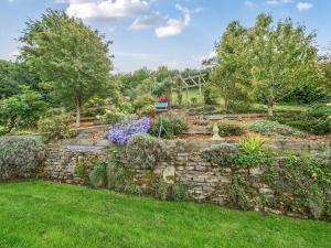 a garden with a stone wall and flowers at Blackthorn House in Blandford Forum