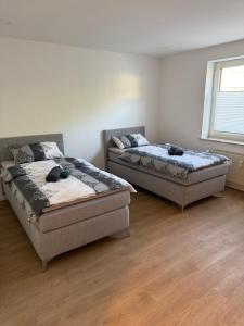 two beds in a room with wooden floors at Schalke Unterkunft in Gelsenkirchen