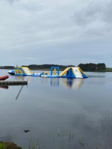 a row of inflatable water slides on a lake at Three Lochs Holiday Park, 139 Loch View with Lazy Spa Hot Tub, Platinum 3 bedroom Holiday Home for Hire in Balminnoch +2 photos