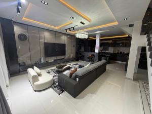 a living room with a couch and chairs and a tv at House 9 Signature in Port Harcourt