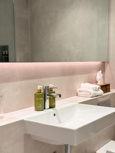 a bathroom with a white sink and a mirror at Fiddle + Bow Hotel in Doolin