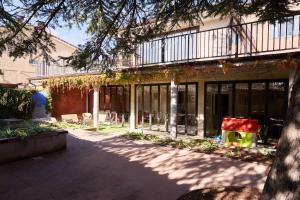 a building with a courtyard with chairs and trees at Casa Rural Las Bengoas in Alesanco