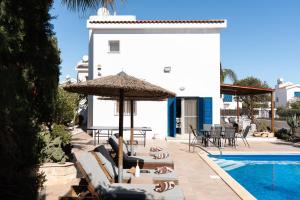 a group of people laying on lounge chairs next to a pool at Dream Olea Villa - Ayia Napa in Ayia Napa