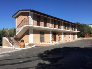 a large brick building with a balcony on a street at B&B MULA Germaneto in Santa Maria