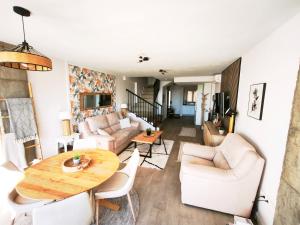 a living room with white furniture and a wooden table at Duplex Apartman with sunny terrace in Mijas Pueblo in Mijas
