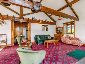 a living room with green furniture and a red rug at The Barton in Launceston