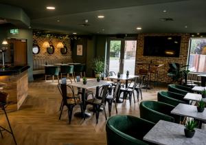 a restaurant with wooden tables and green chairs at Nine Yards Bell Tents - Lytham in Lytham St Annes