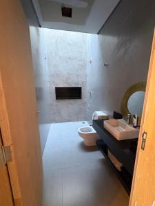 a bathroom with a toilet and a sink at Recanto Gil Viana in Pouso Alegre