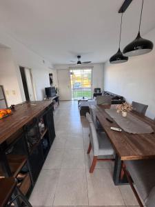 a living room with a wooden table and a couch at Beautiful fully-equipped duplex in Ezeiza