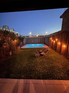a backyard with a swimming pool at night at Beautiful fully-equipped duplex in Ezeiza
