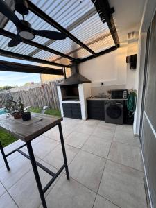 an outdoor kitchen with a table and a stove at Beautiful fully-equipped duplex in Ezeiza