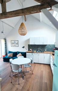 a kitchen and a living room with a table and chairs at Cottage des Cerisiers in Lens