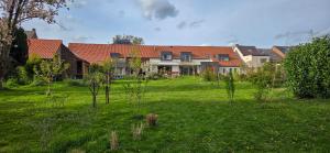 a house with a yard with trees in front of it at Cottage des Cerisiers in Lens
