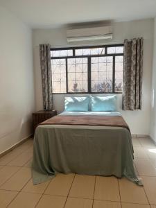 a bedroom with a bed with blue pillows and a window at Morada da Lua in Foz do Iguaçu +9 photos