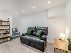 a black leather couch sitting in a living room at The Bunker - Uk40225 in Bardon Mill