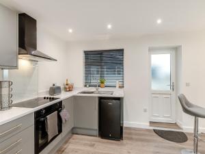 a white kitchen with a sink and a stove at The Bunker - Uk40225 in Bardon Mill +13 photos