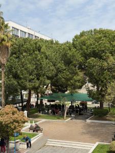 a park with trees and tables and a building at Down Town Apartments in Kavála