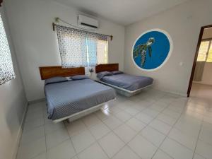 a bedroom with two beds and a window at Casa de las Iguanas Tecolutla in Tecolutla