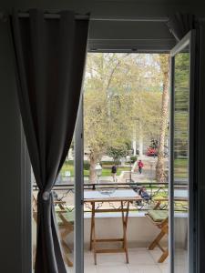 a room with a window with a table and a view of a park at Down Town Apartments in Kavála