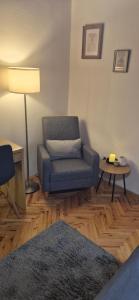 a living room with a blue chair and a lamp at House Dado in Jezerce