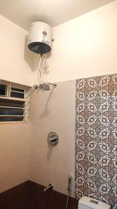 a bathroom with a toilet and a light on the wall at The Prime Residences of Samuels Comfort Homes in Bangalore +61 photos