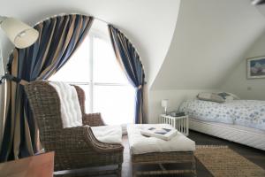 a bedroom with a bed and chairs and a window at Ferienhaus Dwarslöper mit Sauna und Garten in Fuhlendorf in Fuhlendorf