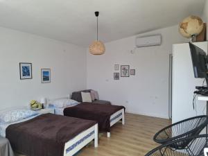 a bedroom with two beds and a flat screen tv at Apartmans White perl in Sutomore